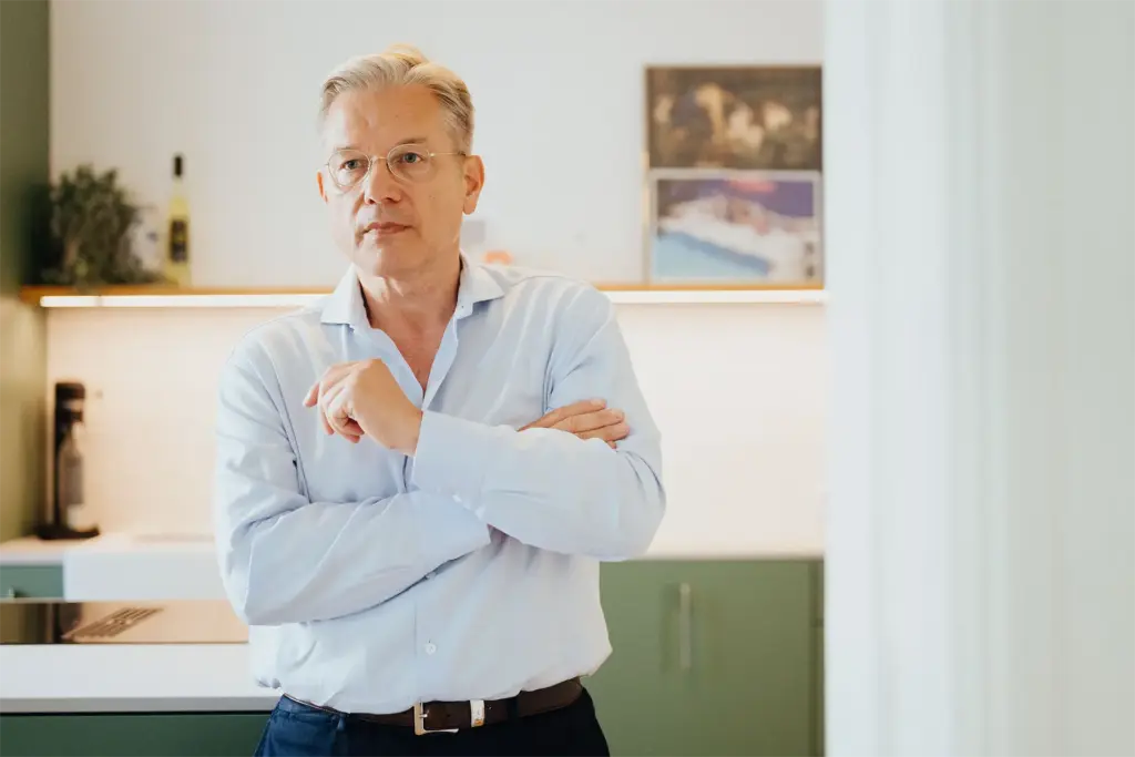 Ulrich Weinkath steht in einer Küche einer Klientenwohnung. Er scheint sehr nachdenklich.